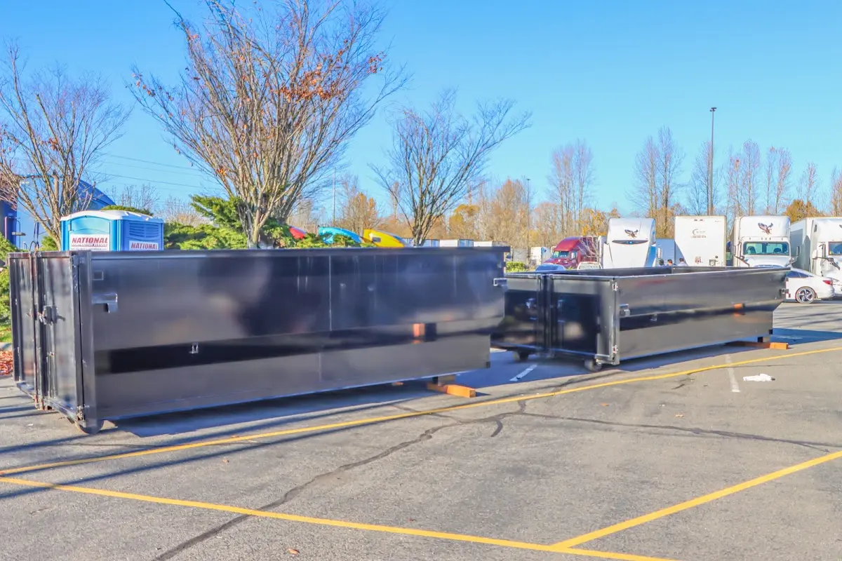 Professional dumpster rental service with roll-off container on residential driveway in Wyldwood